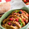 A baked overnight French toast casserole served in a sage green ceramic dish.