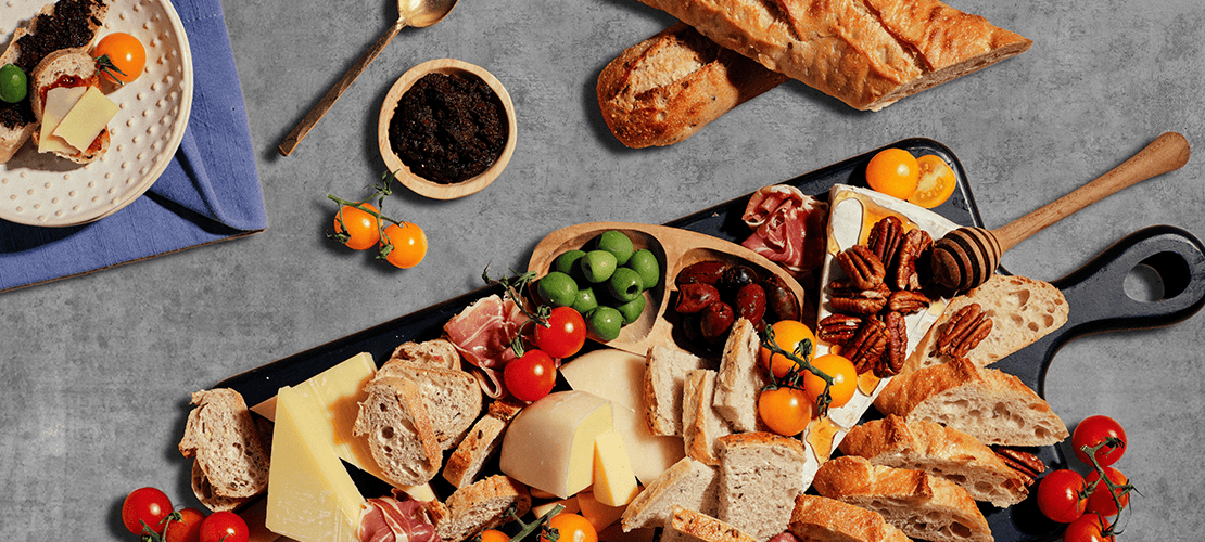 This image features a vibrant grazing board filled with an assortment of cheeses, breads, and colorful accompaniments.