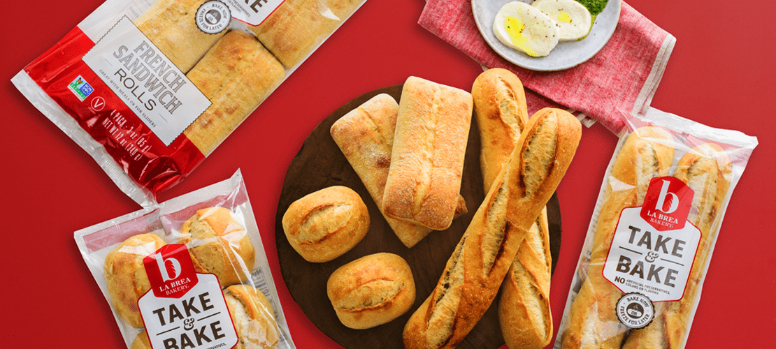 This image showcases a variety of La Brea Bakery bread products, including French sandwich rolls, ciabatta rolls, and baguettes.