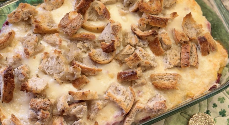 Overhead shot of St Patrick's Day Reuben Casserole featuring New York Rye Loaf artisan bread with festive decorations surrounding the dish