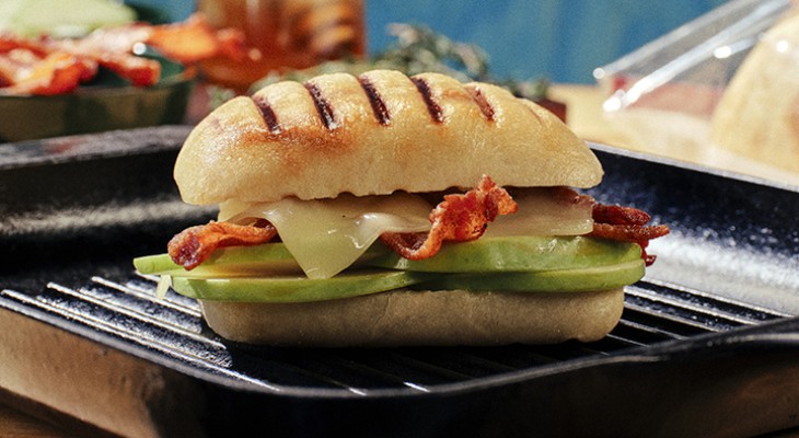 Apple, gruyere and bacon panini on Ciabatta roll bread with black cast iron serving plate