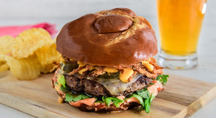 Cast Iron Pretzel Burger with Fried Onions and Nacho Cheese Sauce