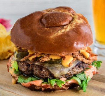 Cast Iron Pretzel Burger with Fried Onions and Nacho Cheese Sauce